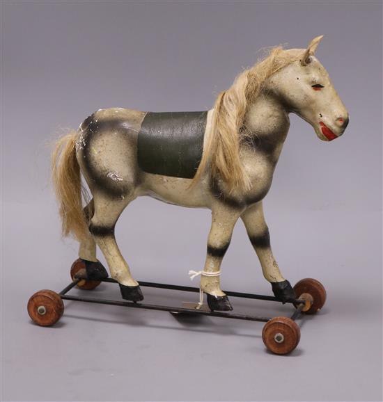 An early 20th century toy horse on wheels height 30cm